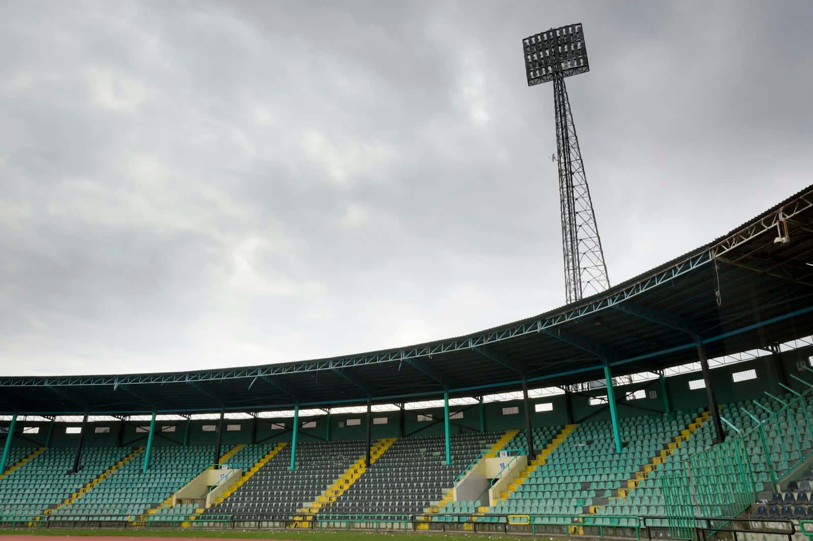 An empty football stand under a floodlight tower