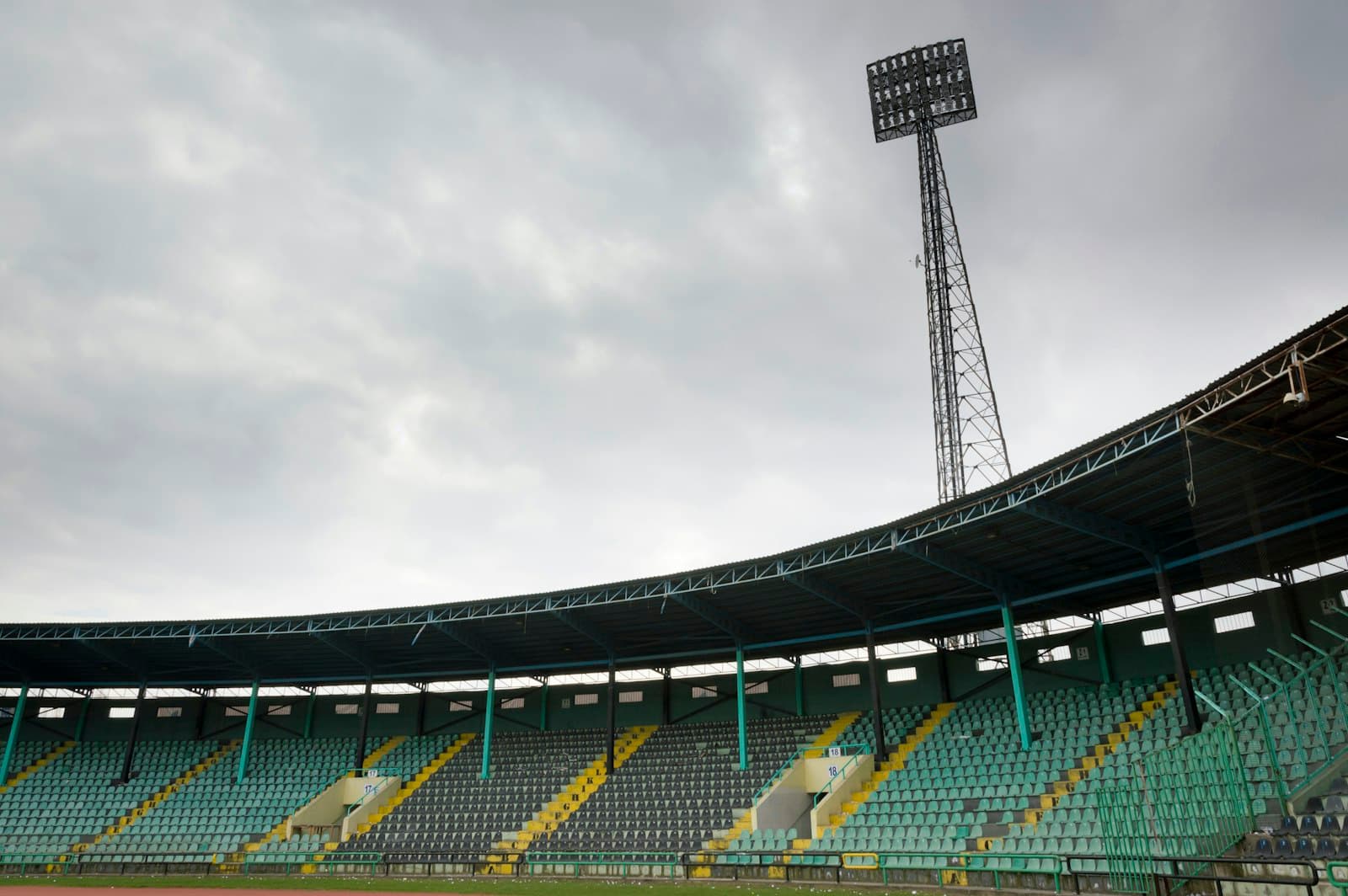 An empty football stand under a floodlight tower