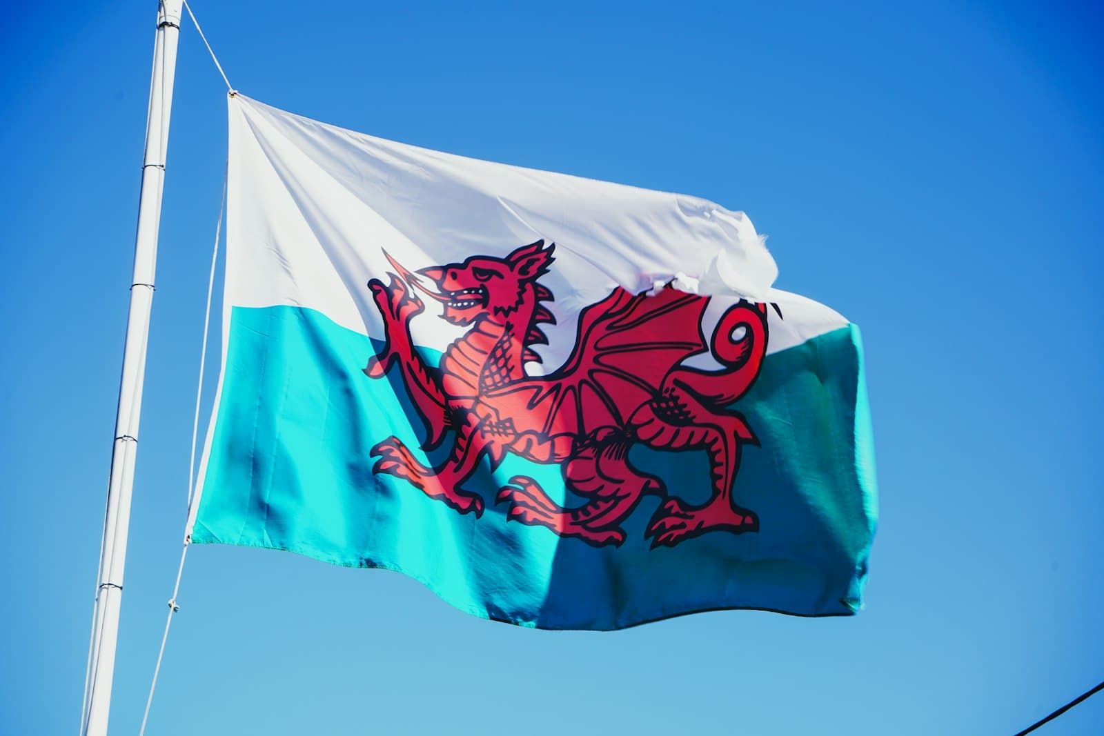 The Welsh flag flying against a blue sky