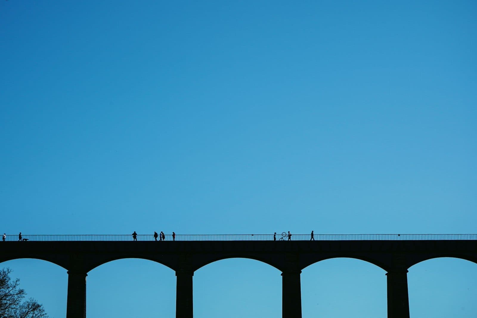 Walkers crossing the Pontcysyllte Aqueduct near Wrexham against a clear blue sky